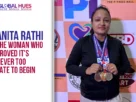 Woman with multiple medals around her neck posing in front of a sponsor backdrop; Anita Rathi poster shown on the left.